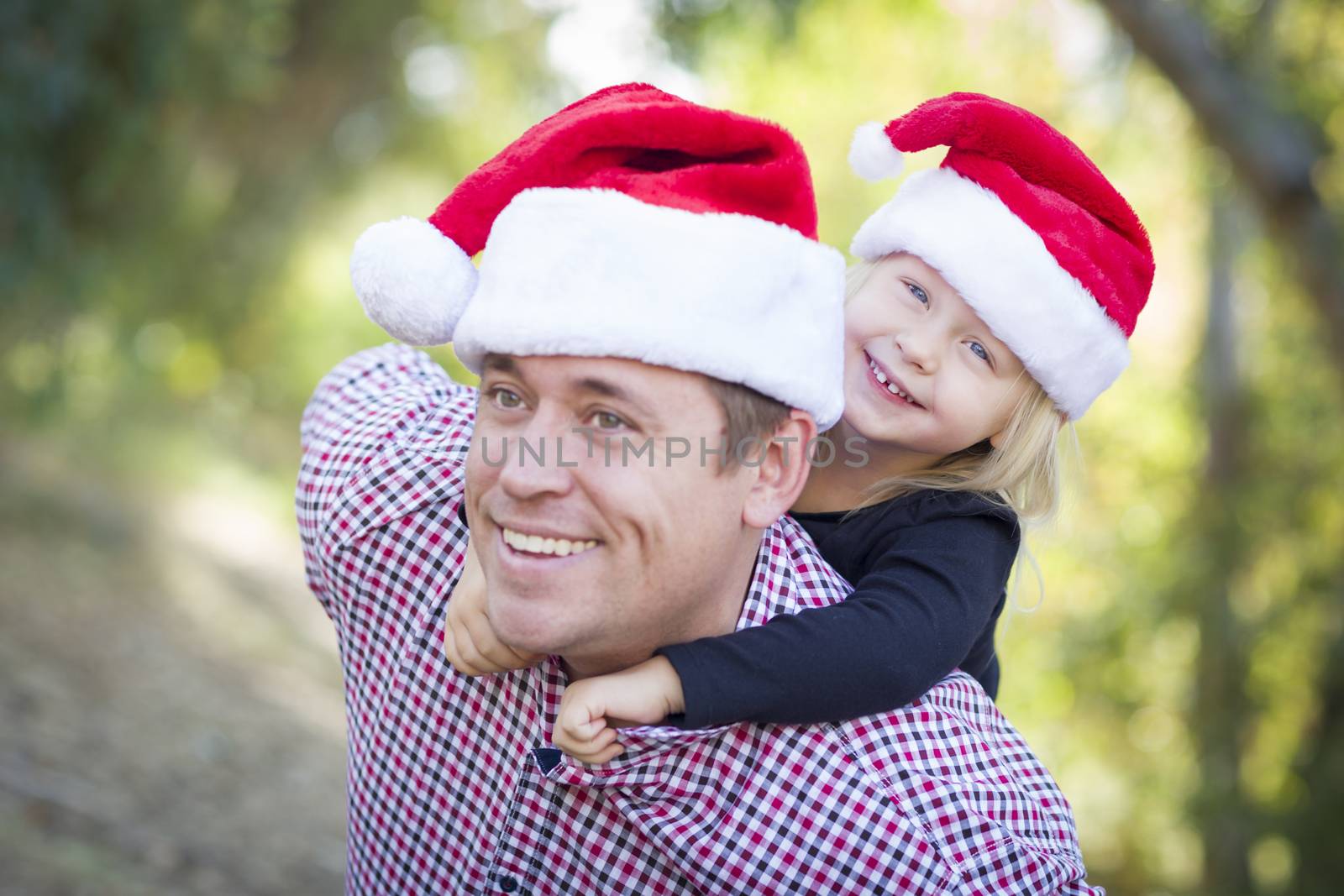 Father and Daughter Having Fun Wearing Santa Hats by Feverpitched