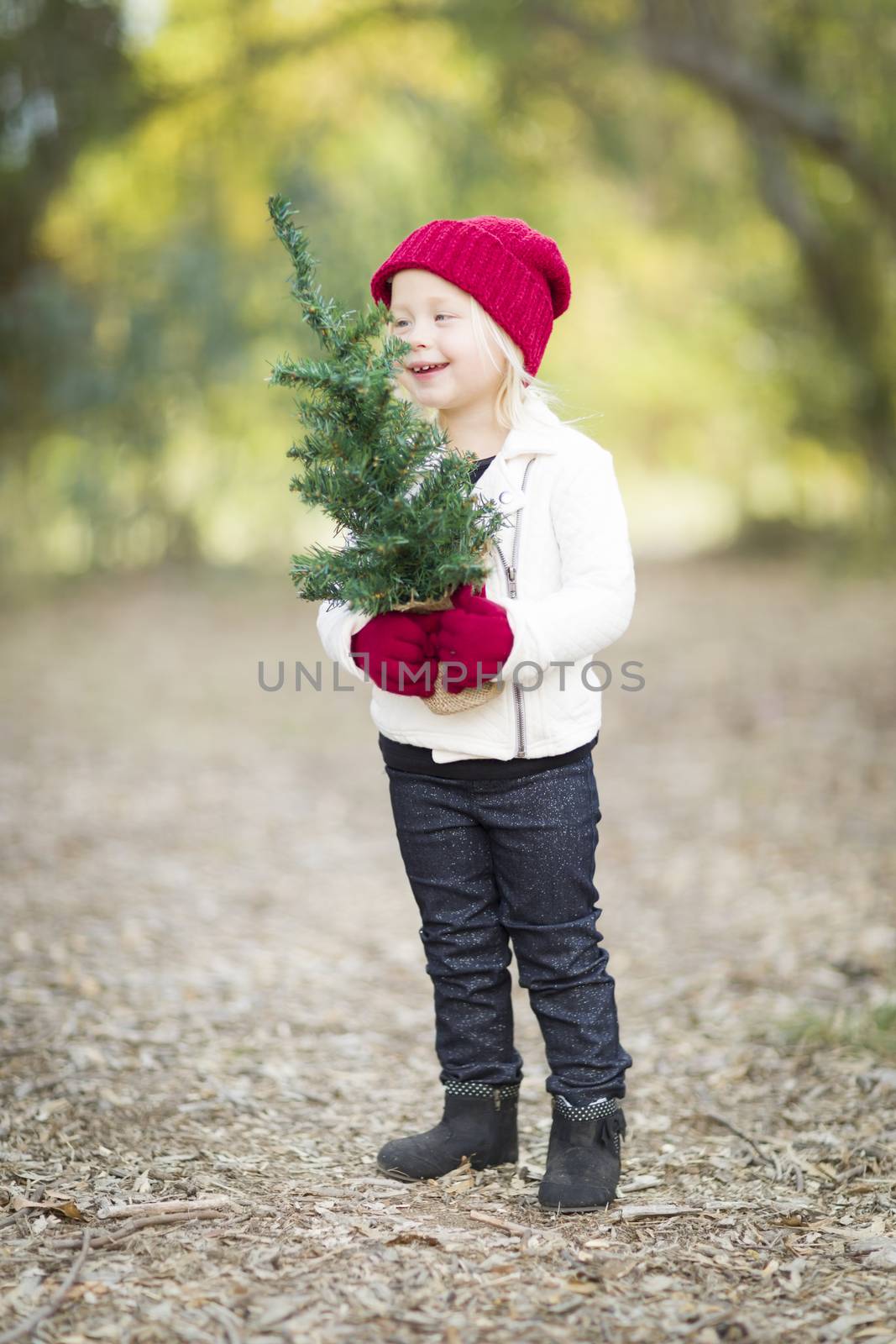 Baby Girl In Red Mittens and Cap Holding Small Christmas Tree by Feverpitched