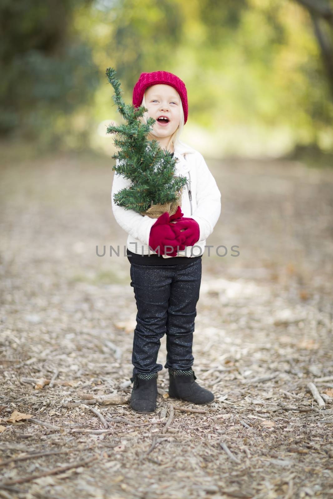 Baby Girl In Red Mittens and Cap Holding Small Christmas Tree by Feverpitched