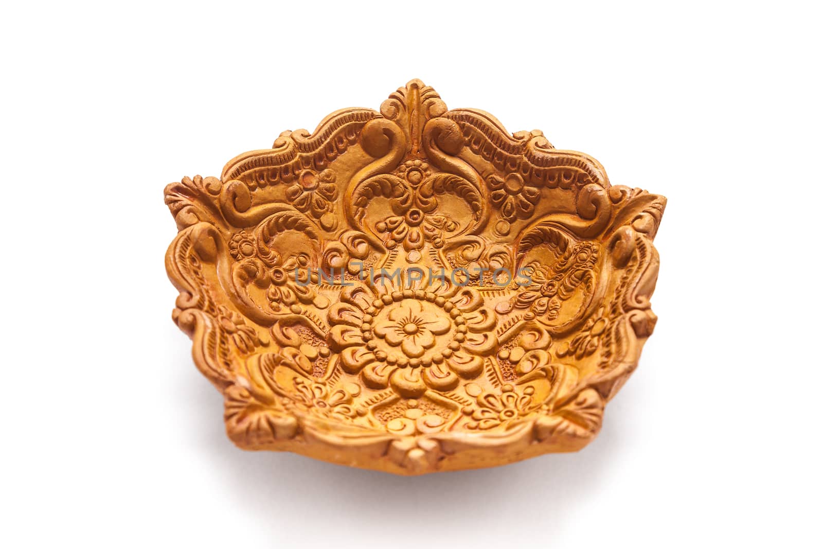 Close up of a beautifully carved designer handmade clay lamp isolated on white background.
