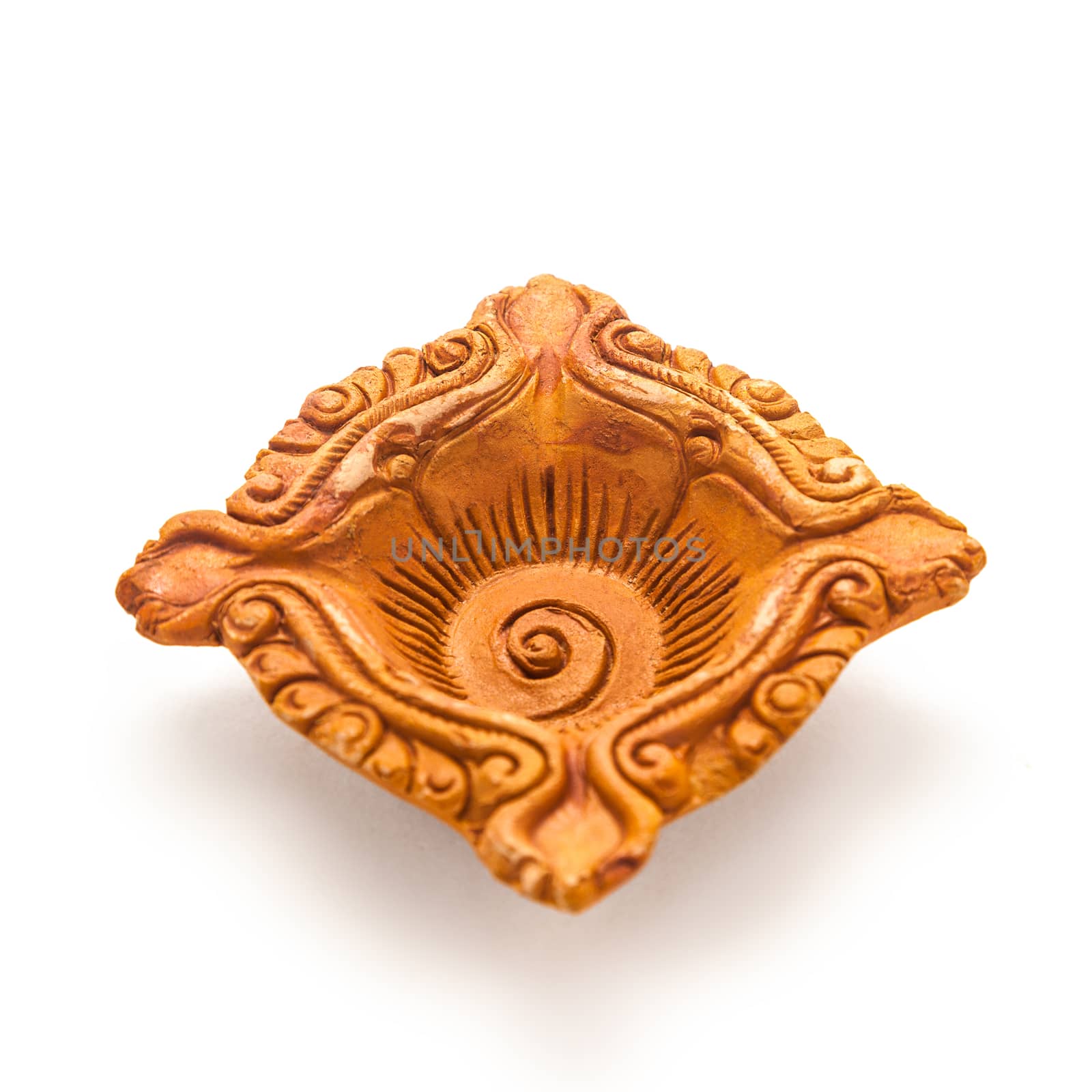 Close up of a beautifully carved designer handmade clay lamp isolated on white background.