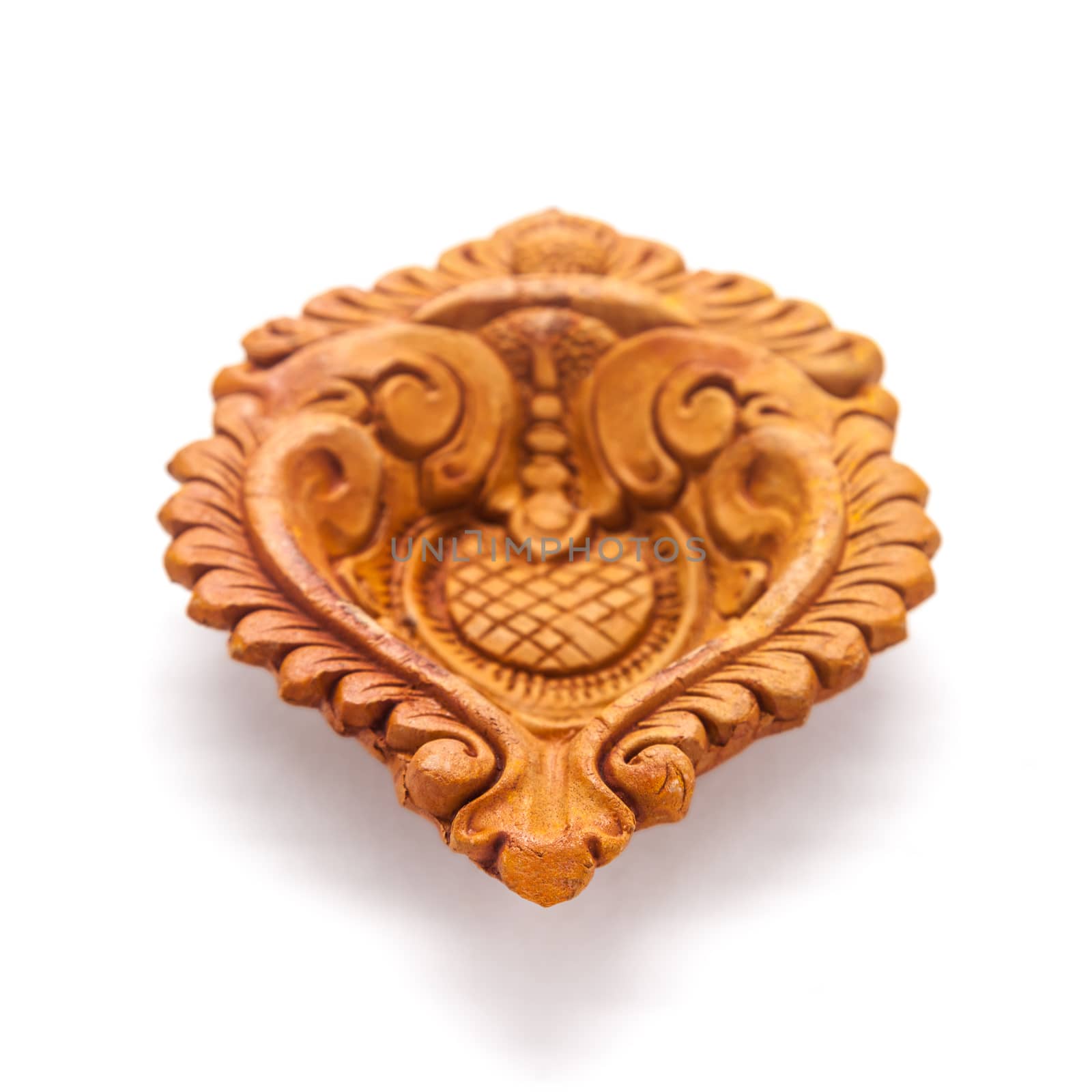 Close up of a beautifully carved designer handmade clay lamp isolated on white background.