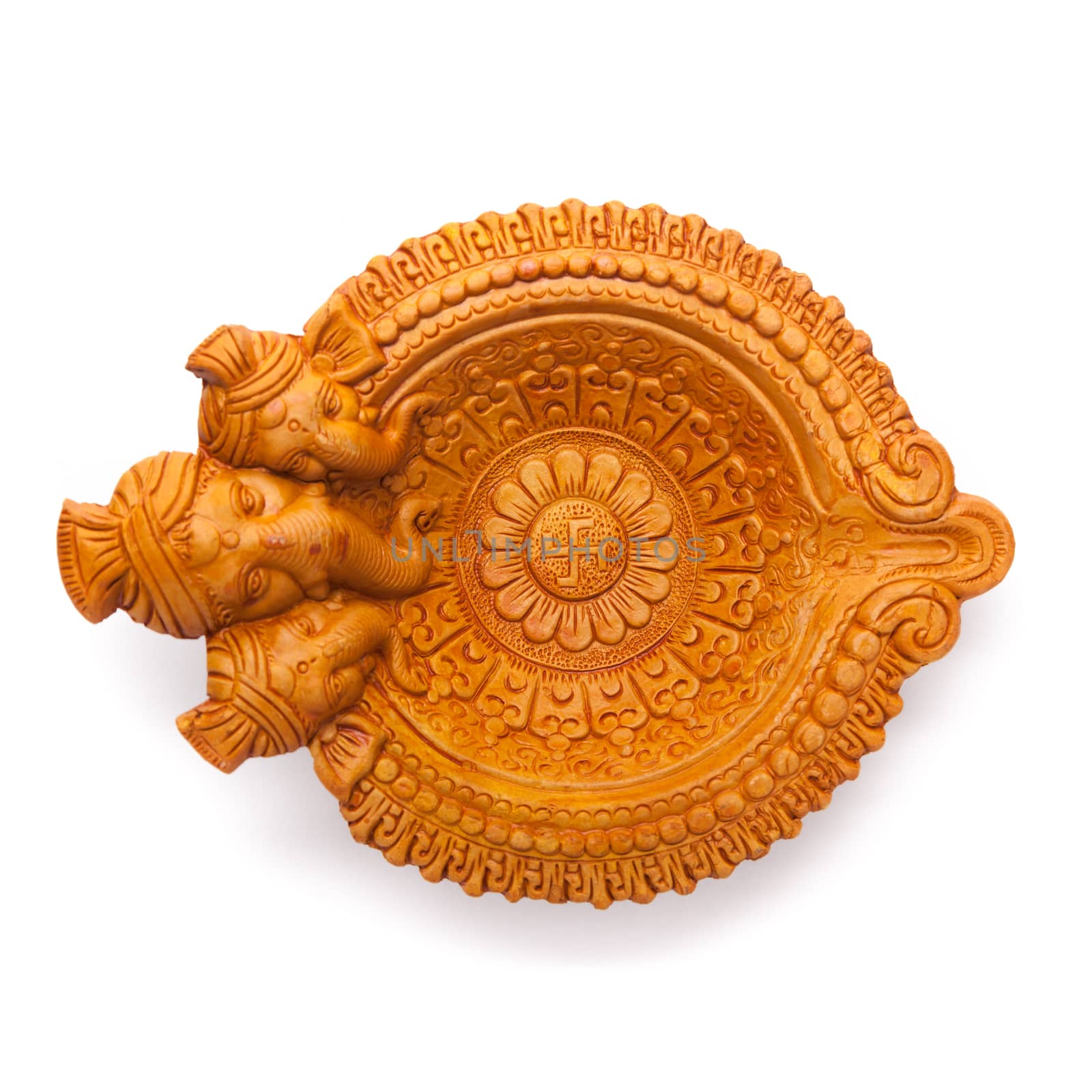 Top view of a beautifully carved designer handmade clay lamp with face of lord Ganesha isolated on white background.