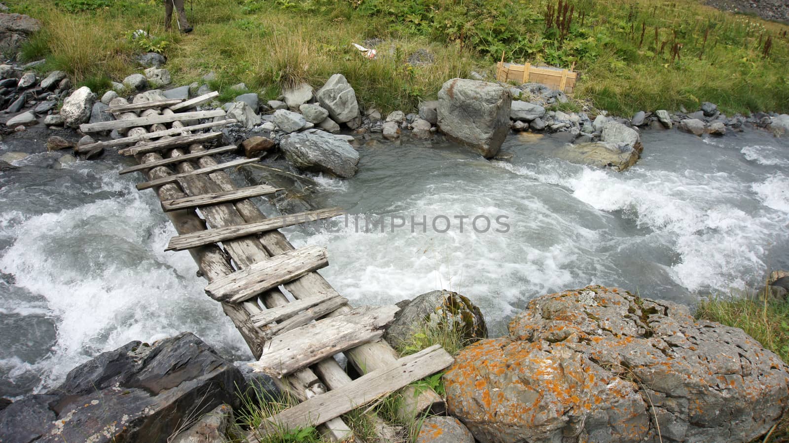 Old timber bridge at mountain river by danemo