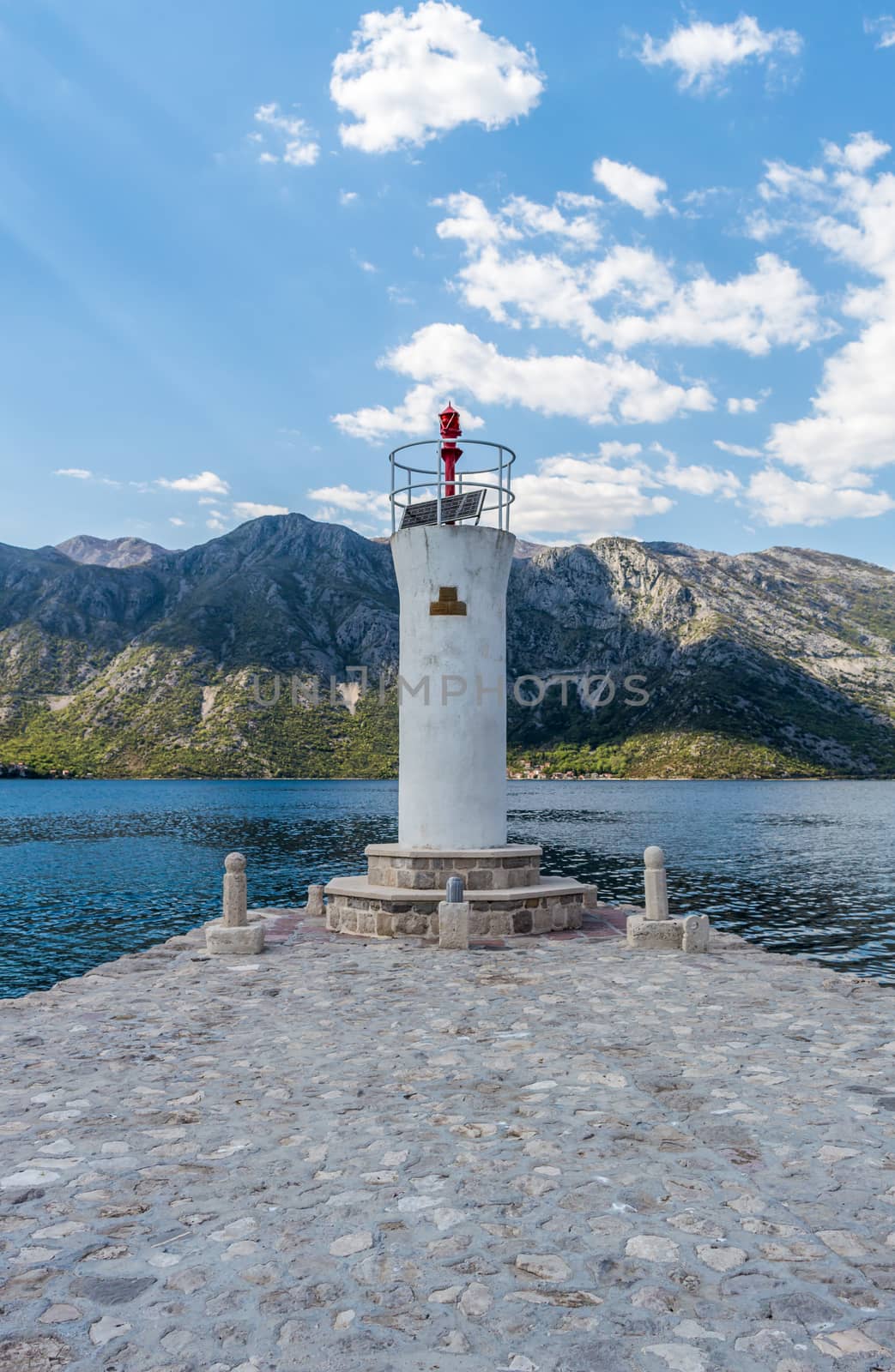 White lighthouse tower on the island in Bay of Kotor  by radzonimo