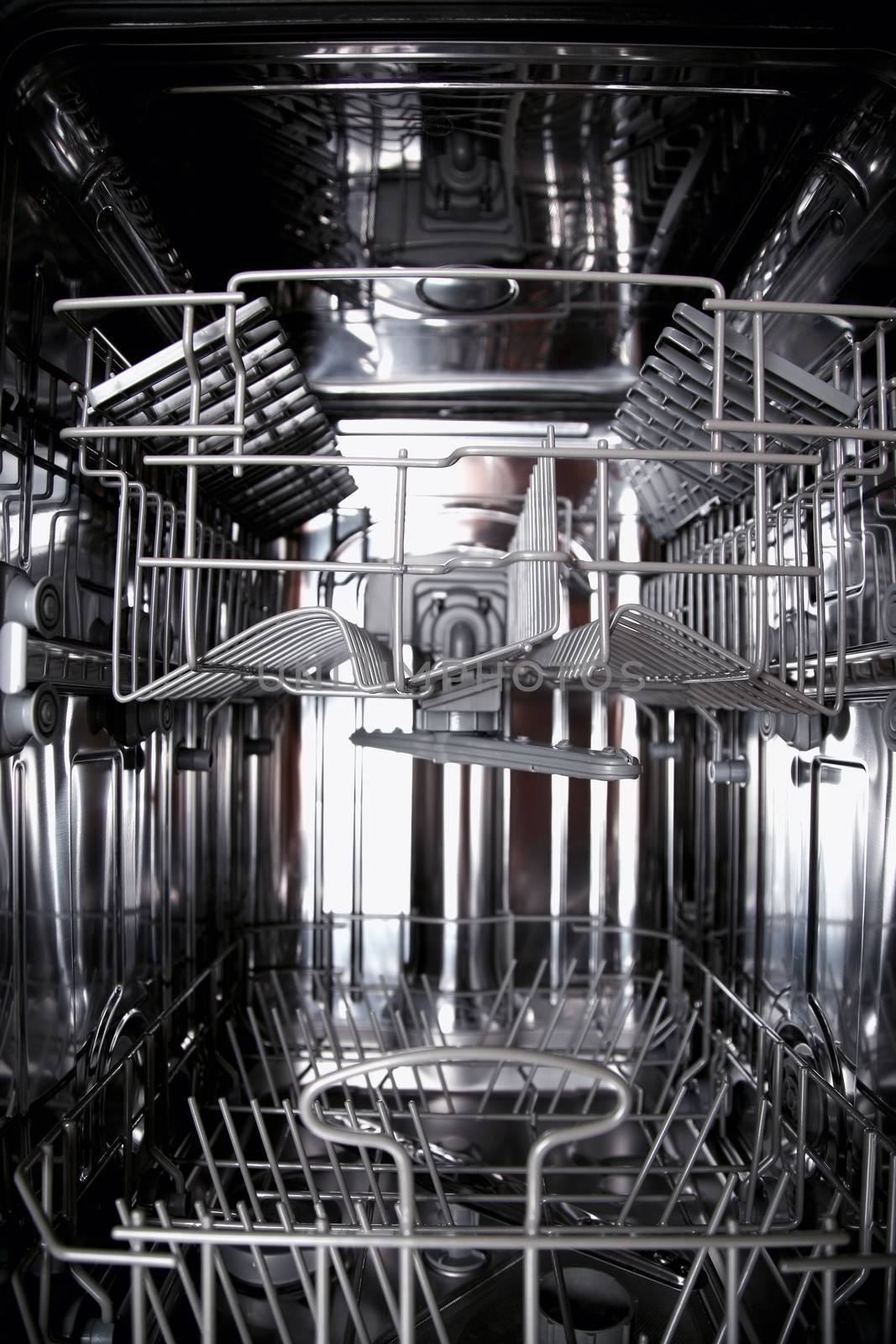 View of the interior of an empty opened dishwasher by vladacanon