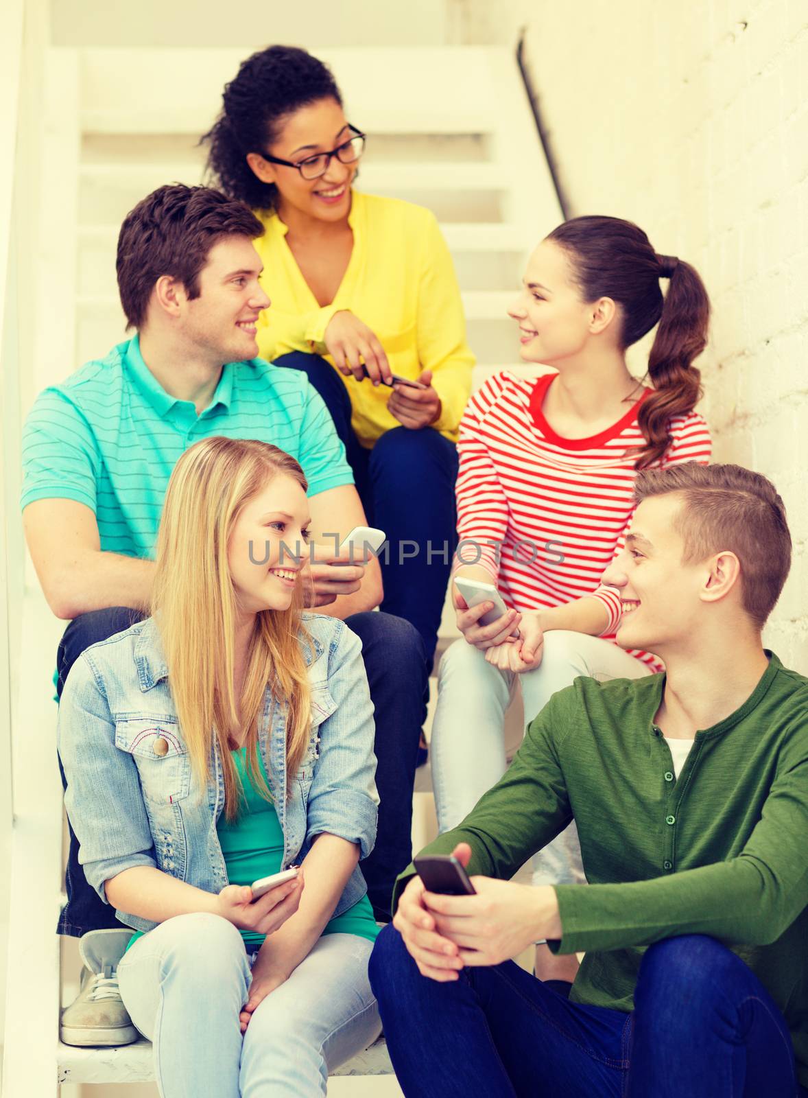 smiling students with smartphone having discussion by dolgachov