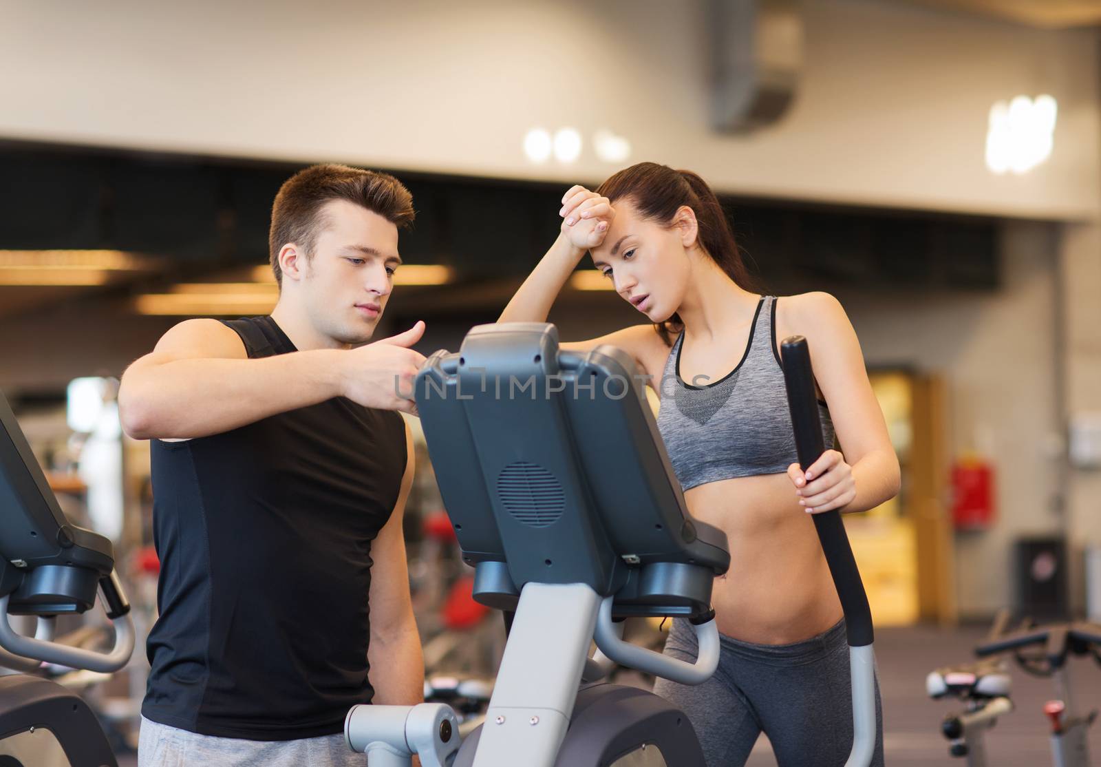 woman with trainer exercising on stepper in gym by dolgachov