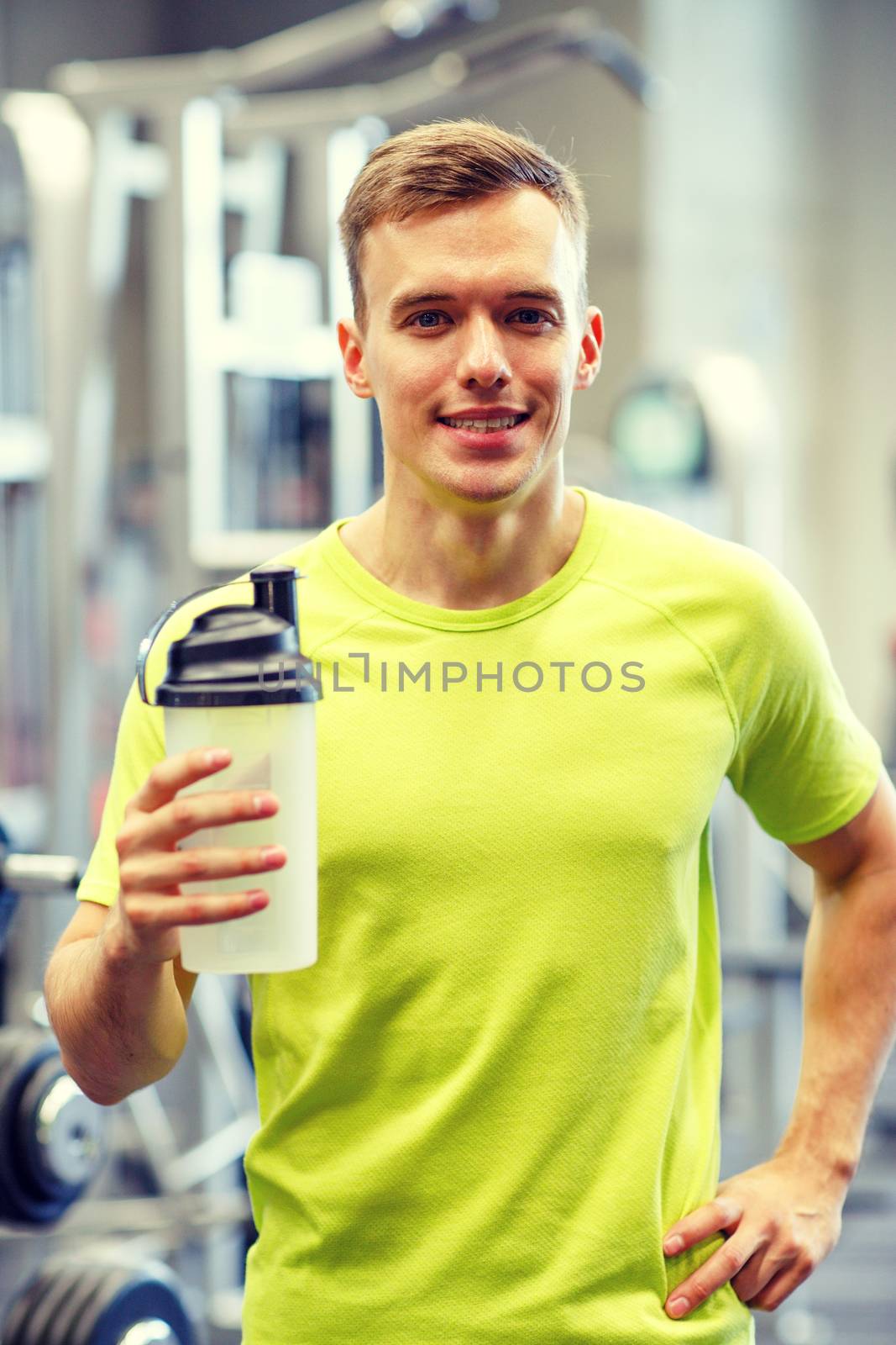 smiling man with protein shake bottle by dolgachov