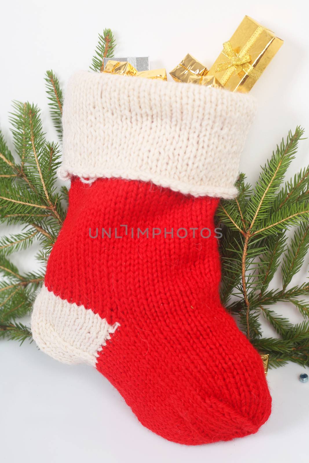 Red Christmas sock with gifts on white background