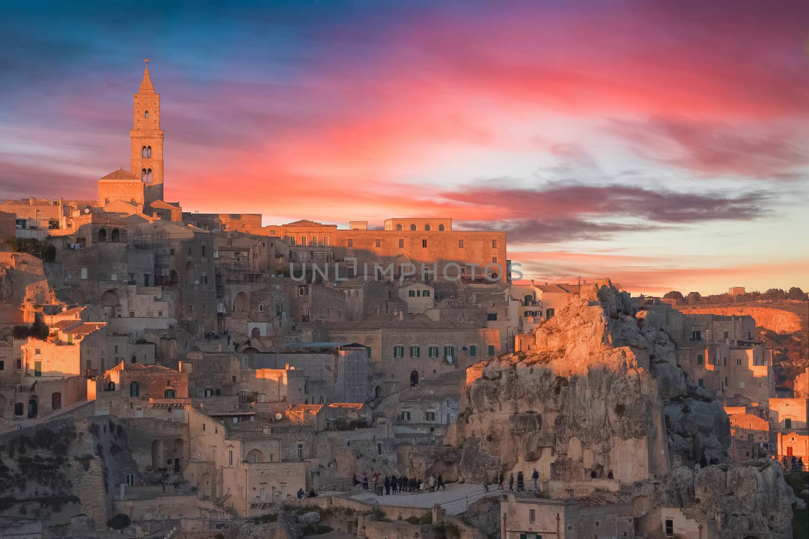 panoramic view of typical stones and church of Matera and the Madonna de Idris under sunset sky. Basilicata, Italy