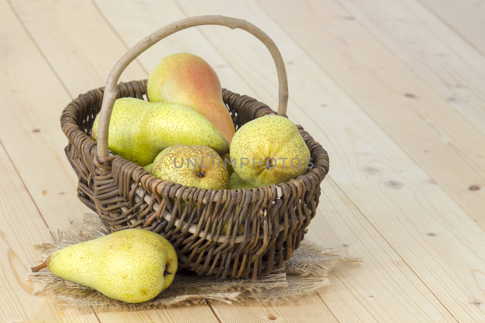 Juicy fresh pears in a basket wooden background