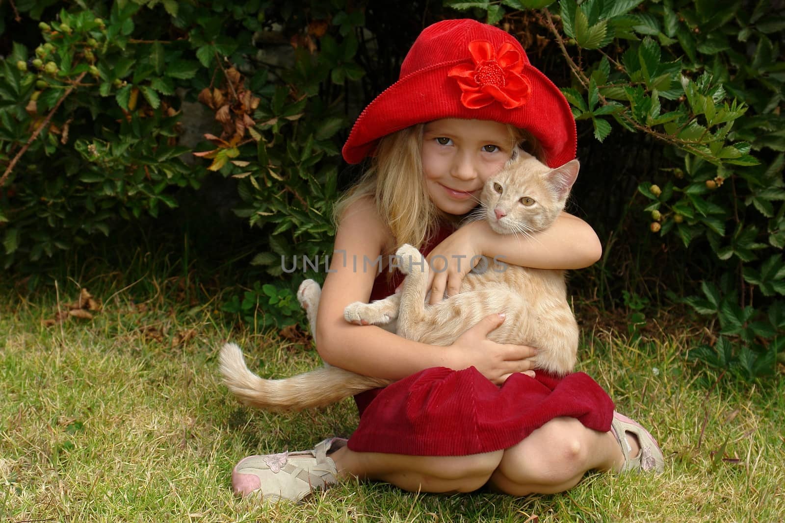Girl in red hat is holding the ginger kitten. by kertis