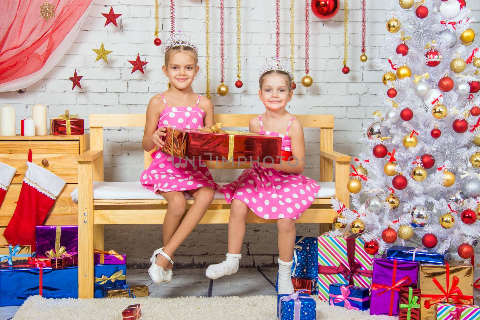 Two funny sisters four girls and six years of playing and having fun in the home New Years interior