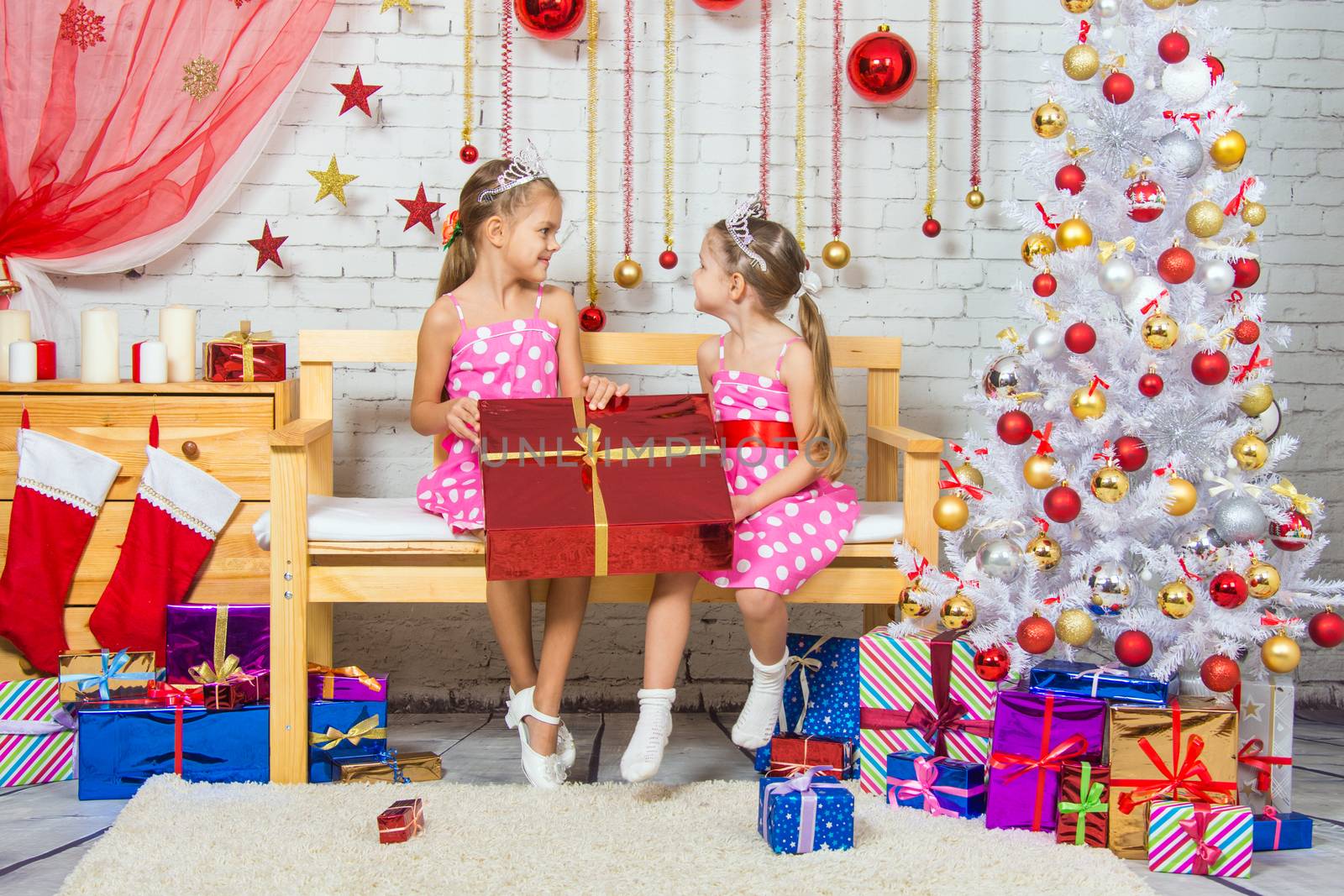 Two funny sisters four girls and six years of playing and having fun in the home New Years interior