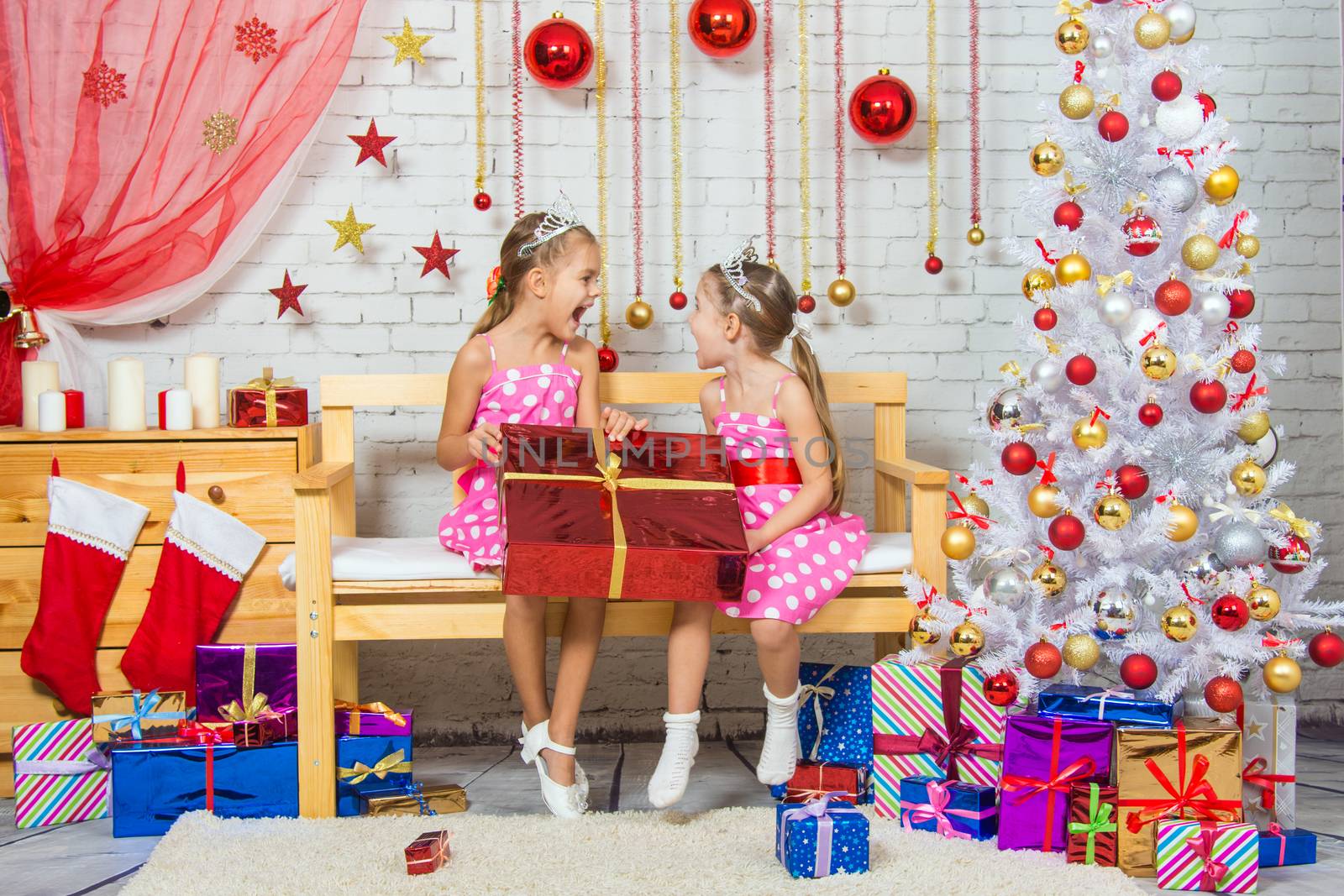 Two funny sisters four girls and six years of playing and having fun in the home New Years interior