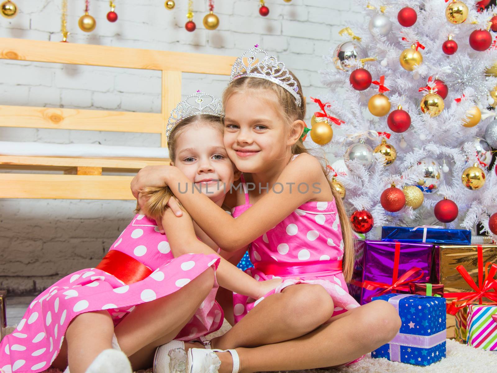 Two funny sisters four girls and six years of playing and having fun in the home New Years interior