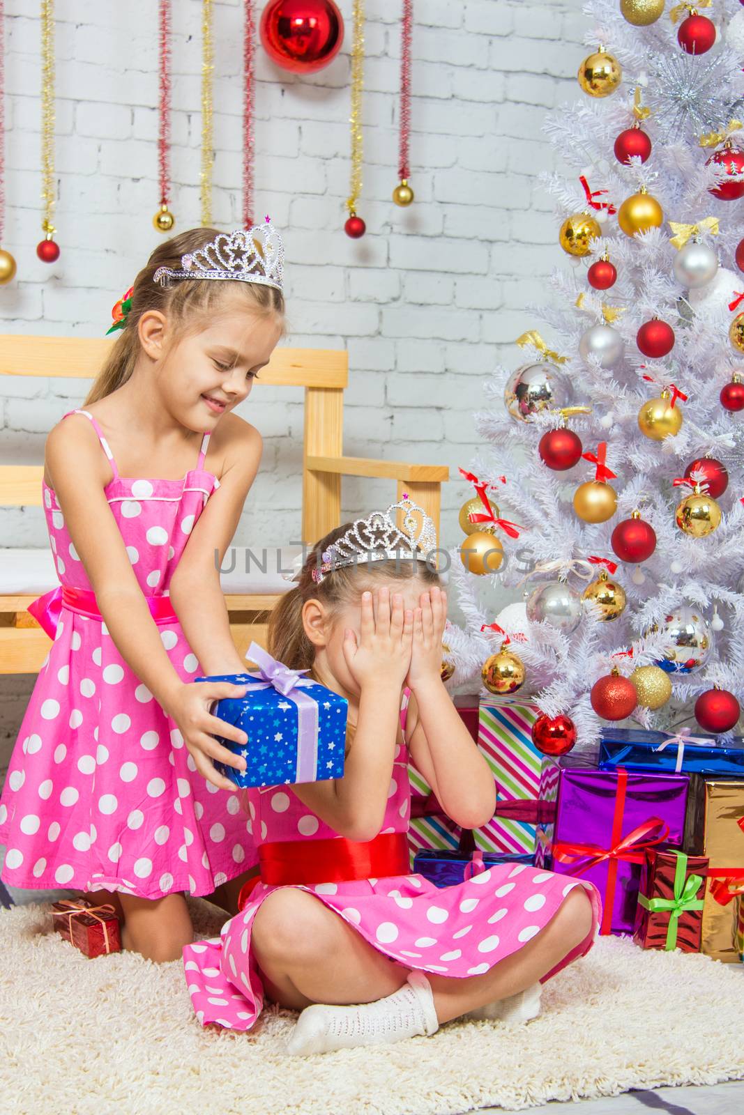 Two funny sisters four girls and six years of playing and having fun in the home New Years interior