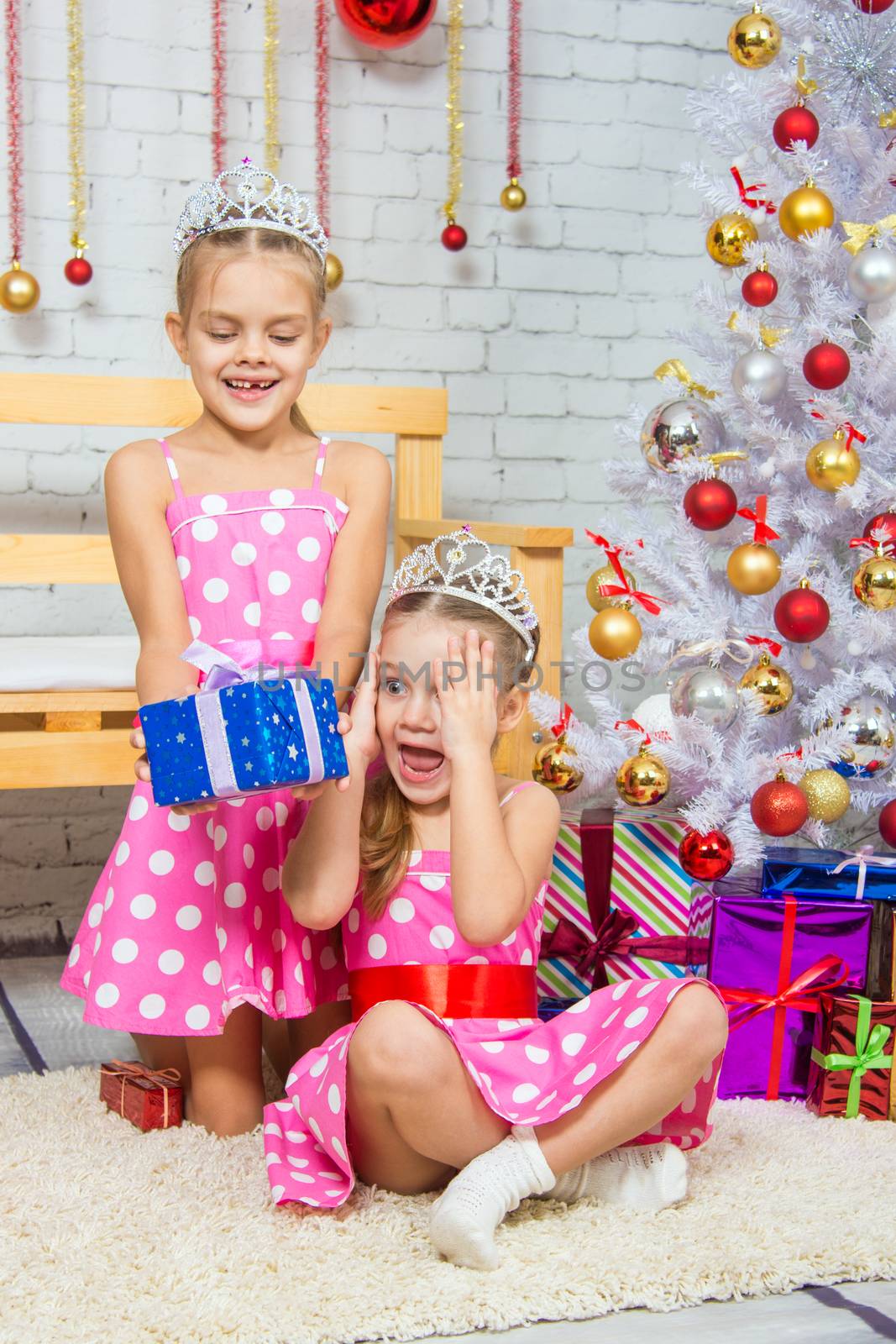 Two funny sisters four girls and six years of playing and having fun in the home New Years interior