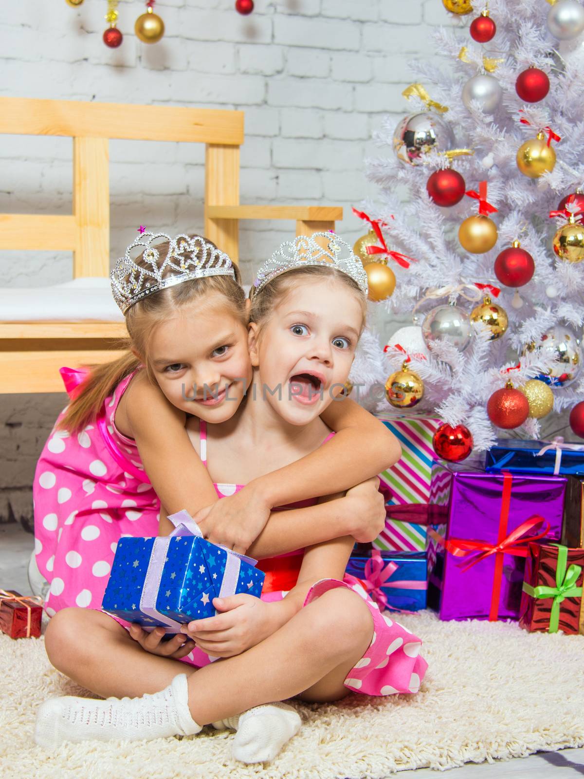 Two funny sisters four girls and six years of playing and having fun in the home New Years interior