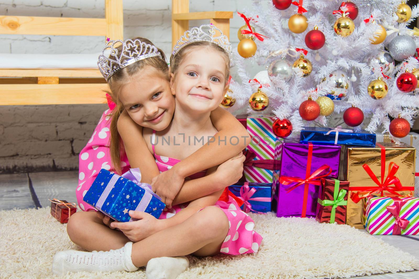 Two funny sisters four girls and six years of playing and having fun in the home New Years interior