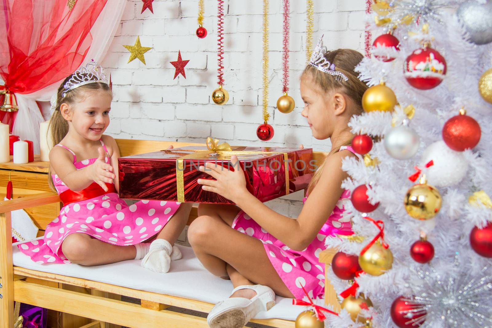 Two funny sisters four girls and six years of playing and having fun in the home New Years interior