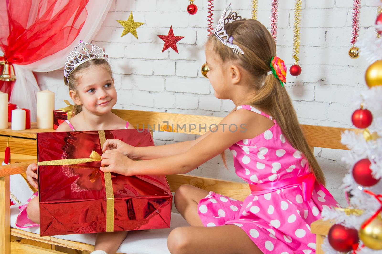 Two funny sisters four girls and six years of playing and having fun in the home New Years interior