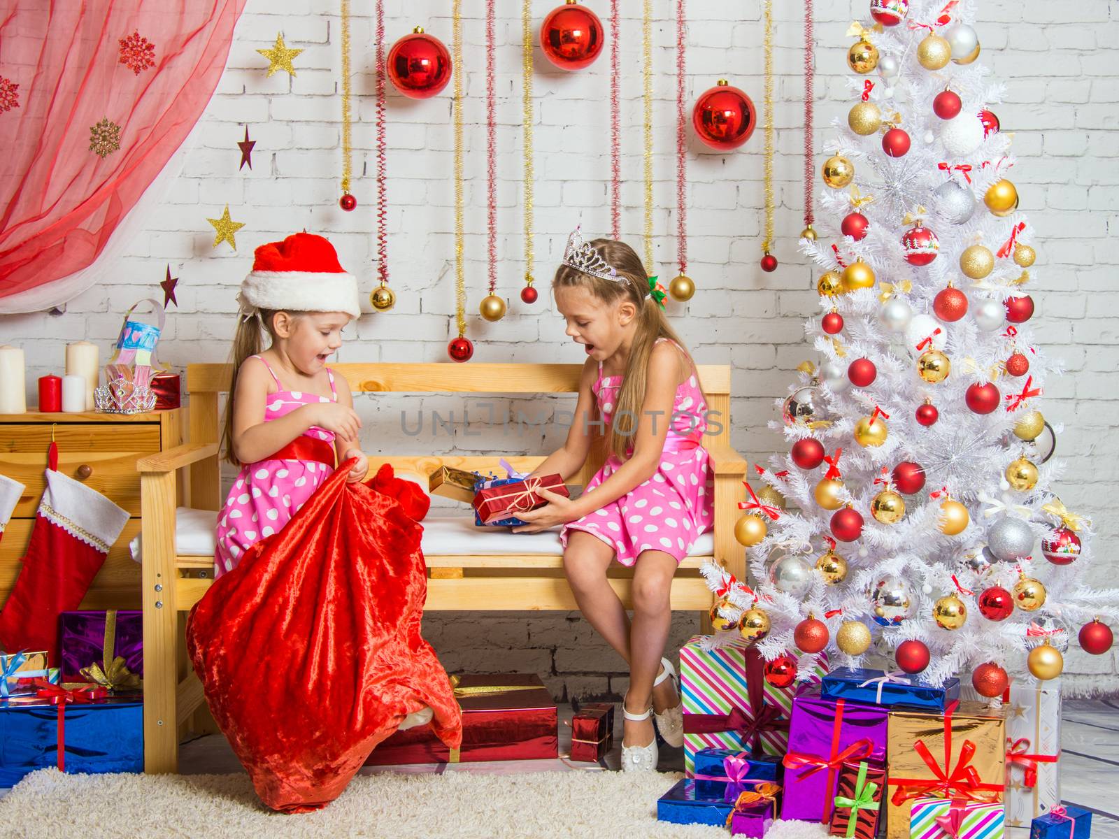 Two funny sisters four girls and six years of playing and having fun in the home New Years interior