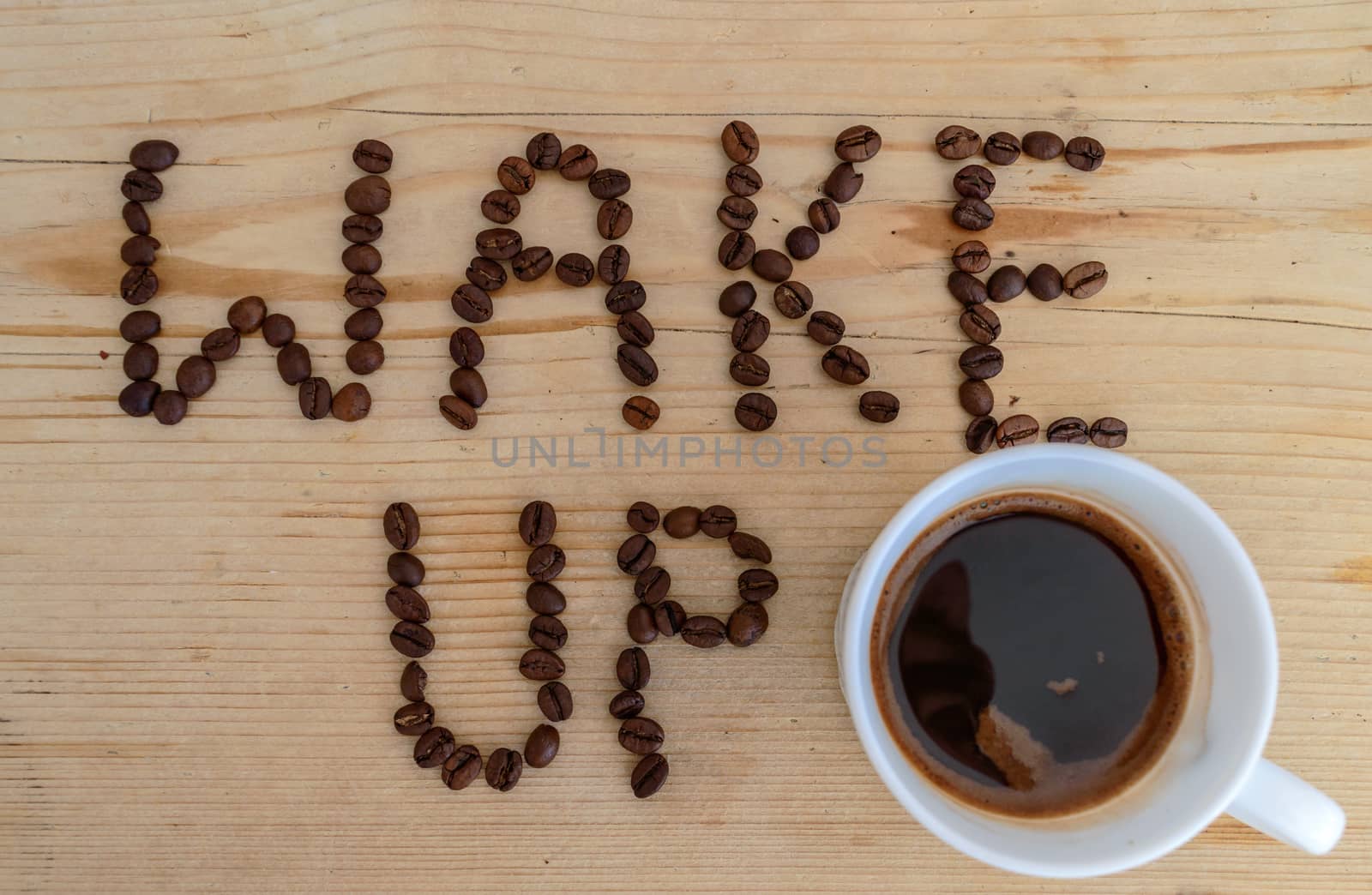 Cup of coffee on wooden background and wake up coffee beans 