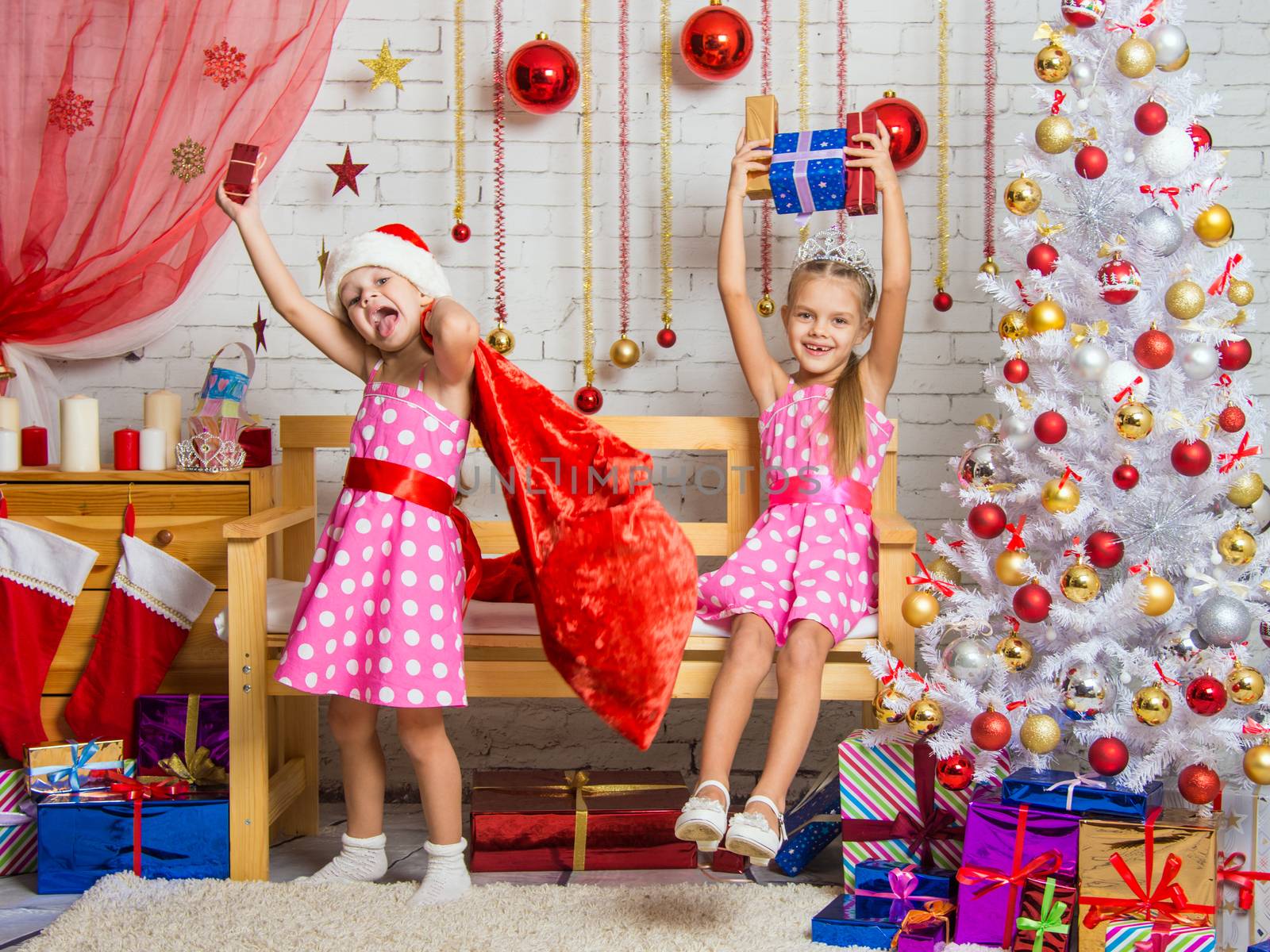 Two funny sisters four girls and six years of playing and having fun in the home New Years interior