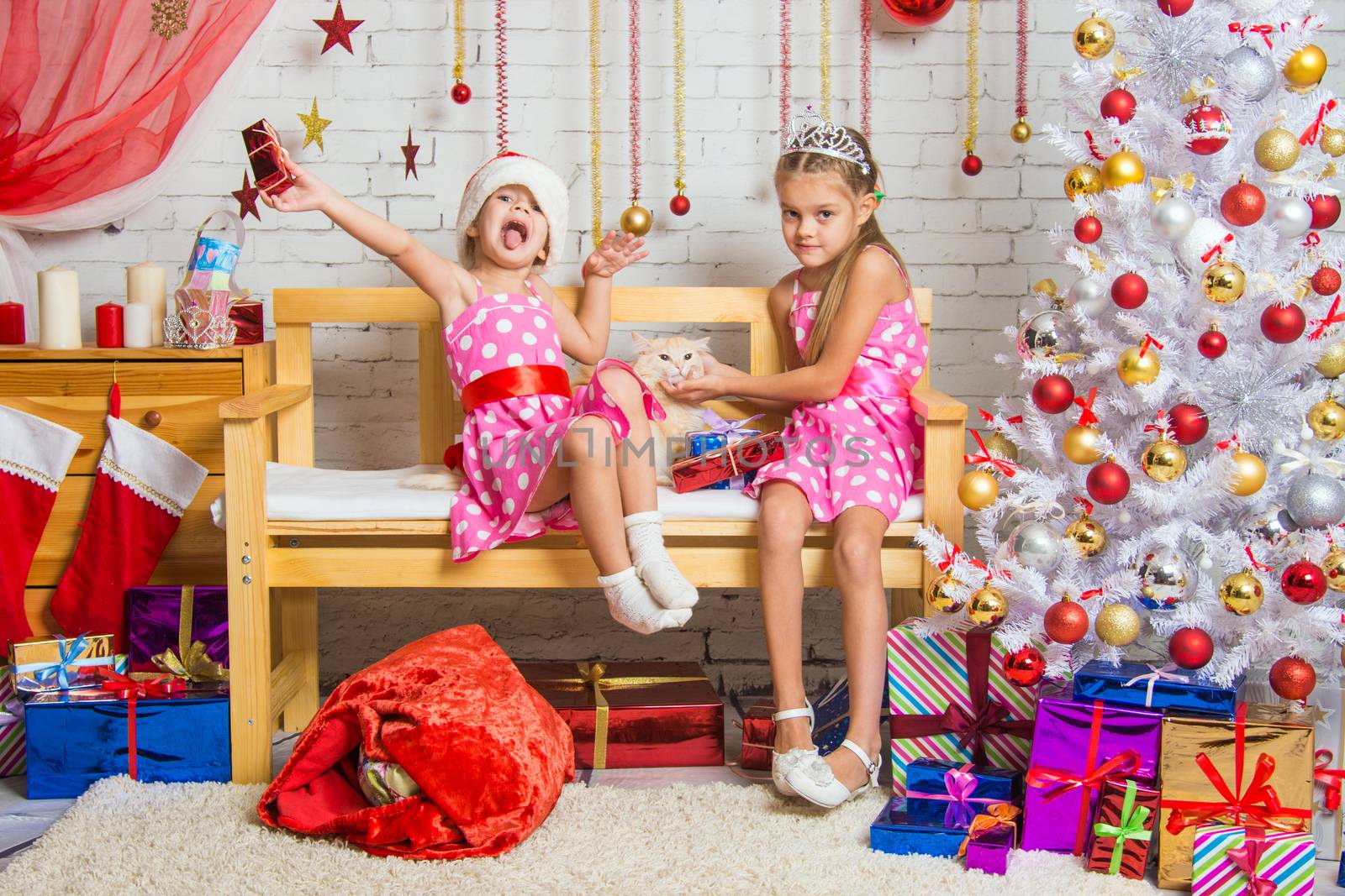Two funny sisters four girls and six years of playing and having fun in the home New Years interior