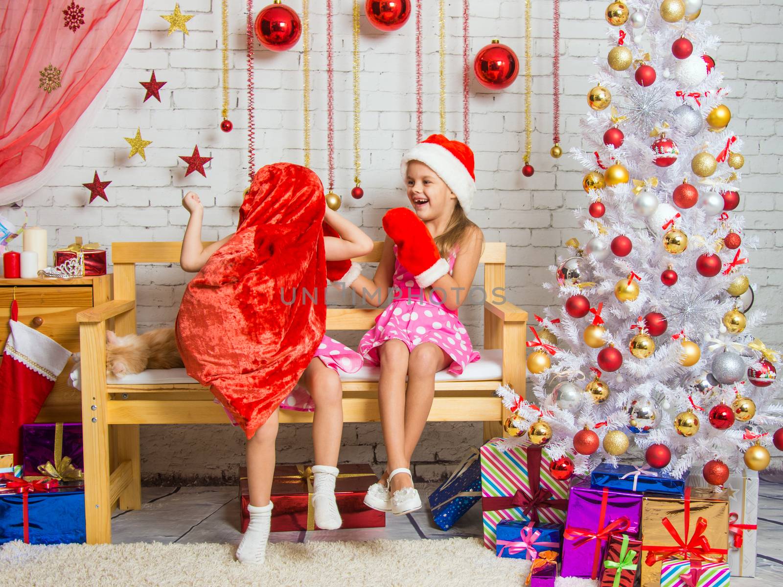Two funny sisters four girls and six years of playing and having fun in the home New Years interior