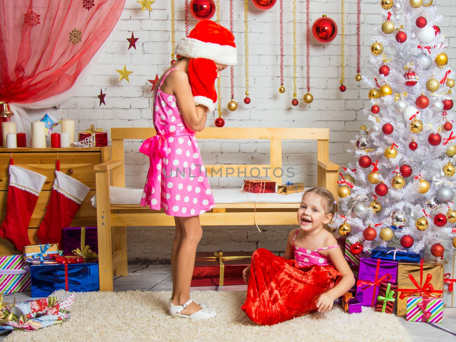Two funny sisters four girls and six years of playing and having fun in the home New Years interior