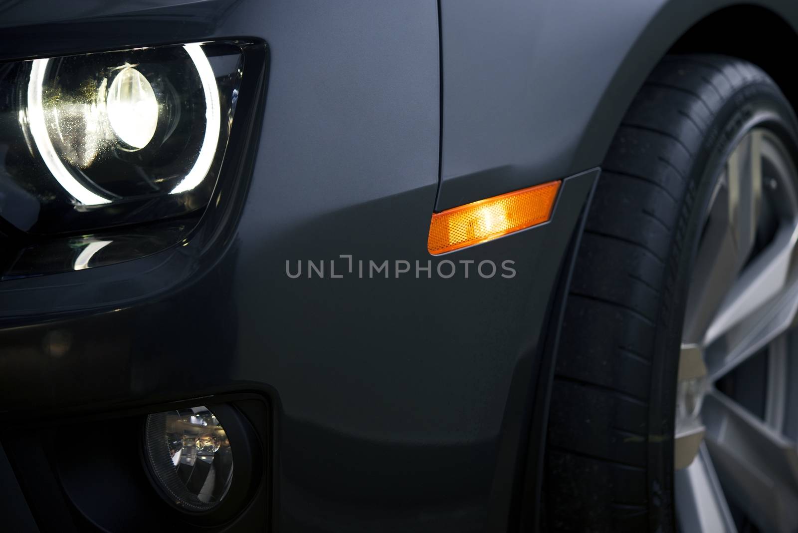 Modern Car Closeup Photo. Headlight and Alloy Wheel Closeup. Modern Transportation.