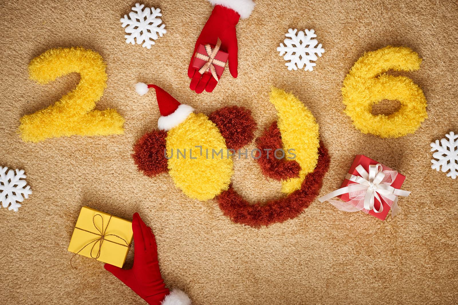 New Year 2016. Christmas.Funny monkey in Santa hat and banana,presents,snowflakes.Happy festive still life,yellow digits handmade, hands in red gloves.Party decoration, unusual holiday card, copyspace