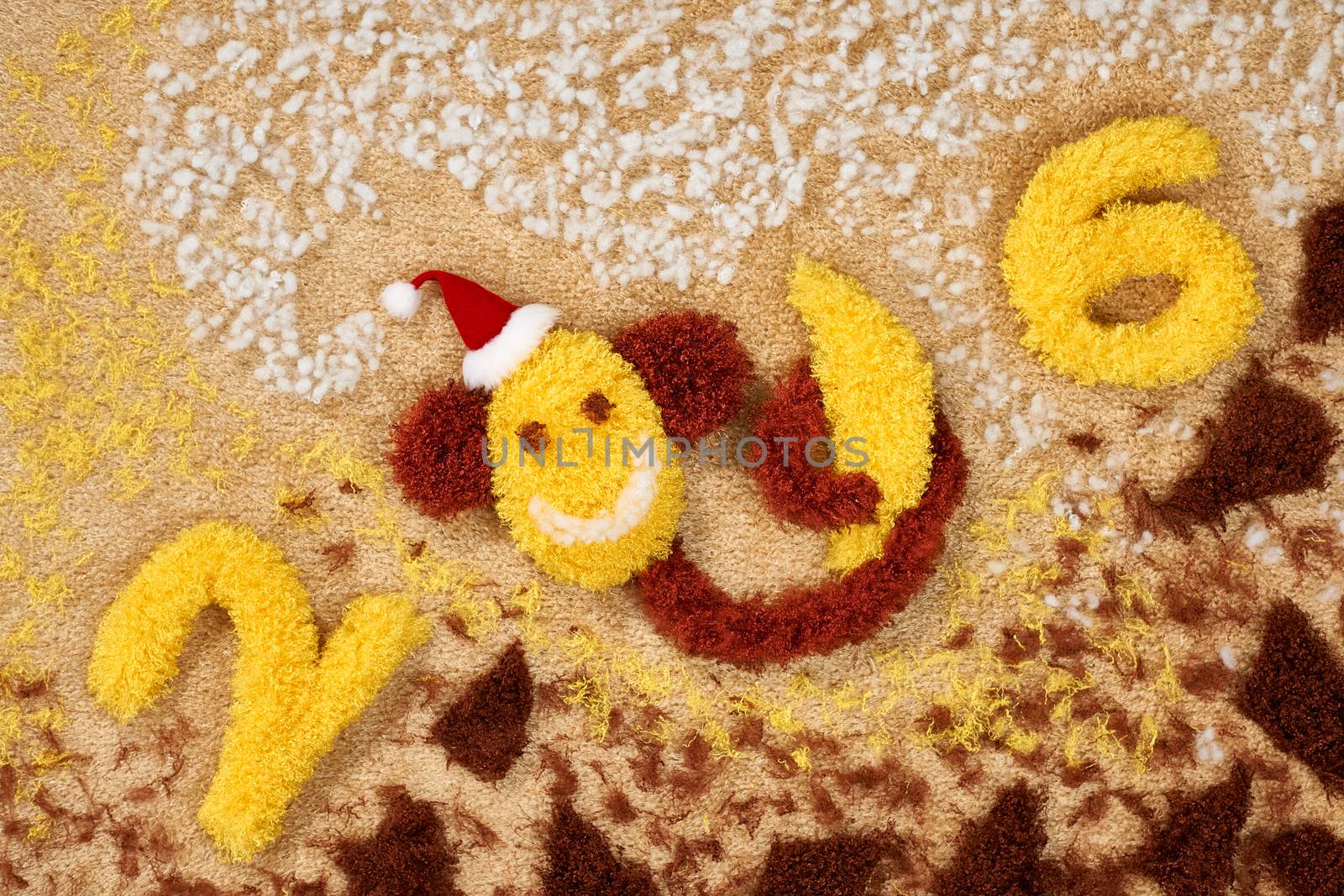 New Year 2016. Christmas.Funny monkey in Santa hat with banana. Happy vivid festive still life. Yellow fabric digits handmade. Playful fluffy party decoration.Shaggy unusual holiday card, copyspace