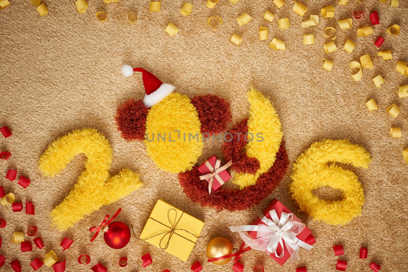 New Year 2016. Christmas.Funny monkey in Santa hat with banana,presents,serpentine. Happy vivid festive still life.Yellow digits handmade. Party decoration, gift box, unusual holiday card, copyspace