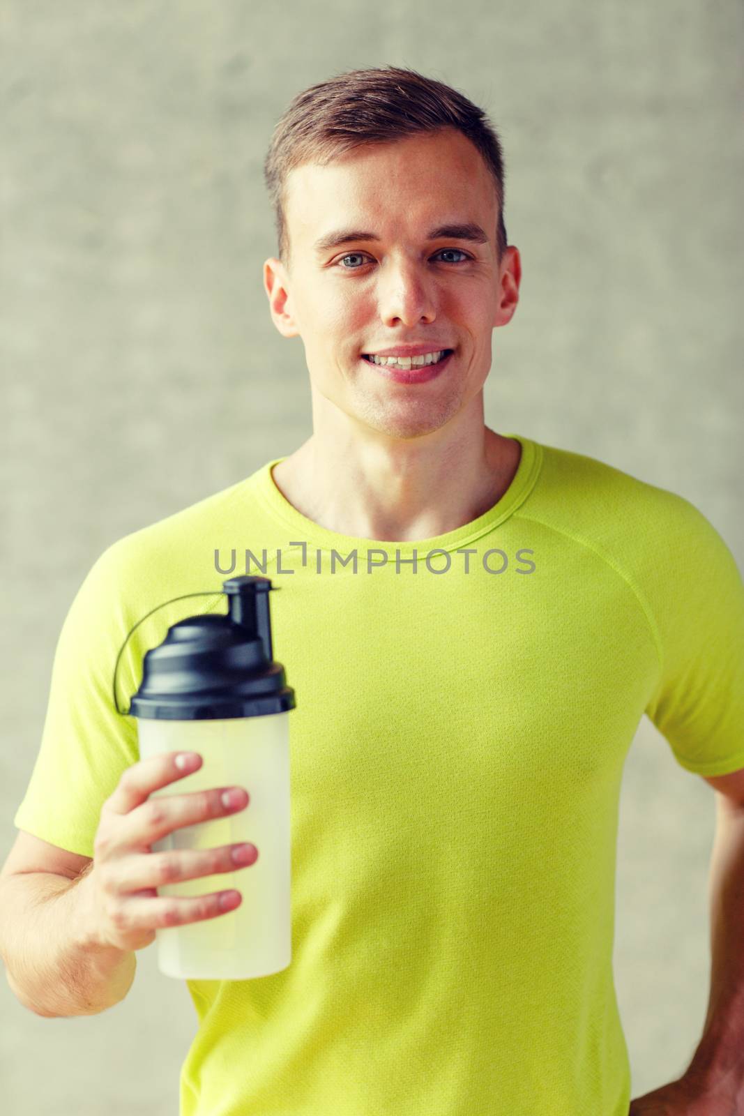 smiling man with protein shake bottle by dolgachov