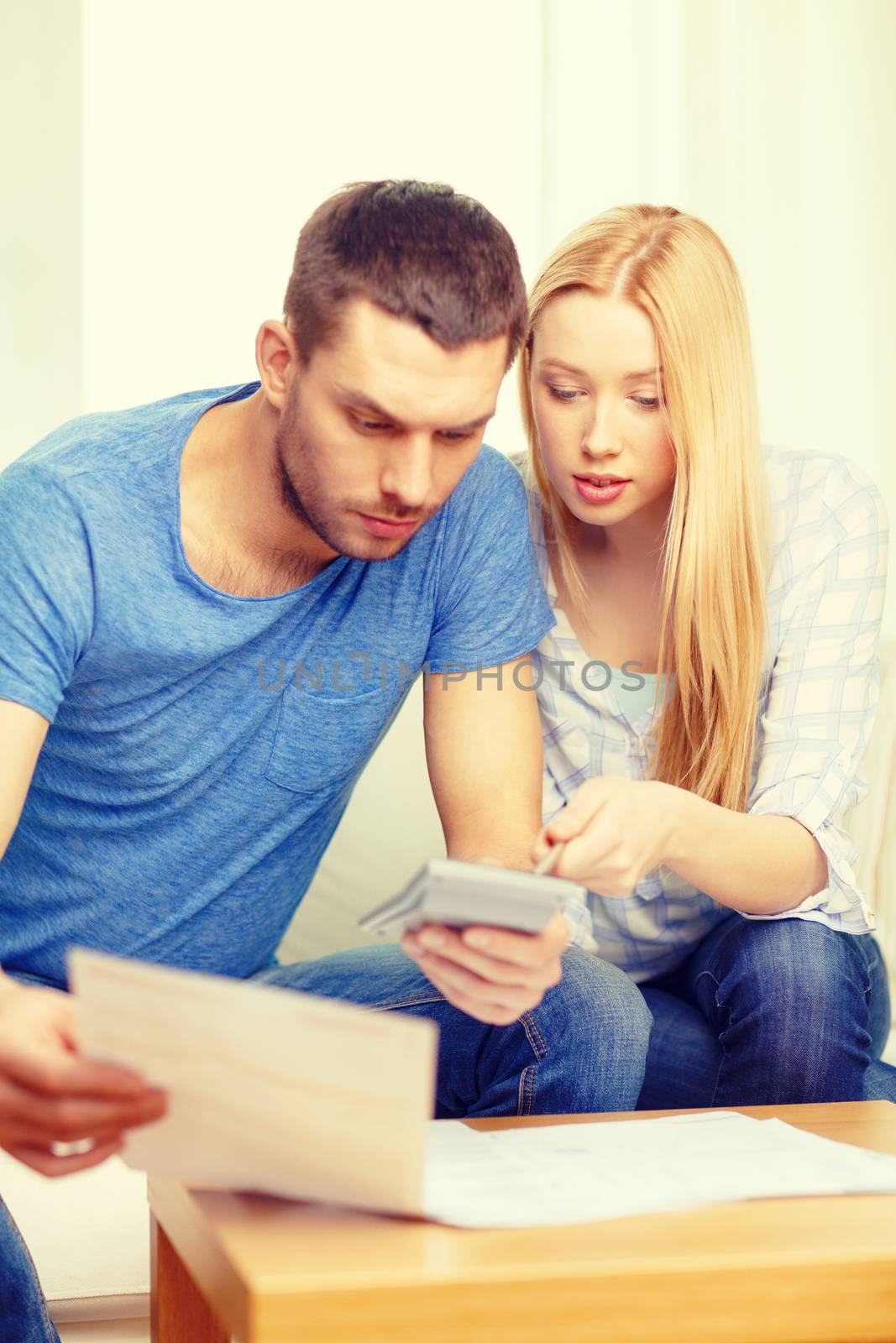 busy couple with papers and calculator at home by dolgachov