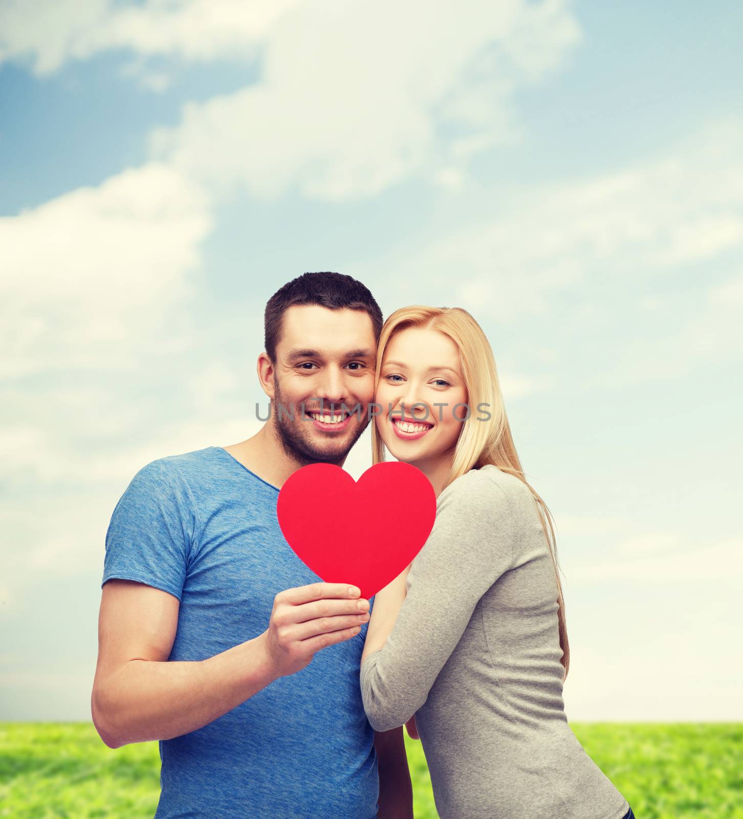 couple, love and family concept - smiling couple holding big red heart