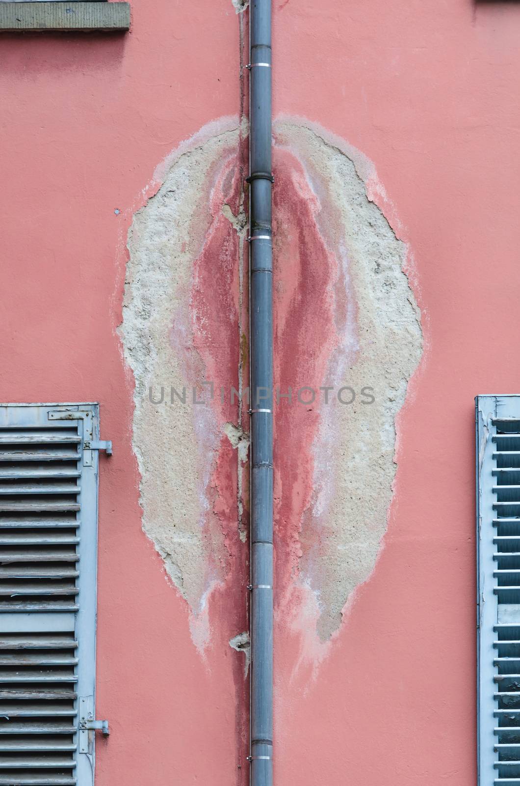 Photo of an old dirty wall with a damaged drain pipe for rain water.