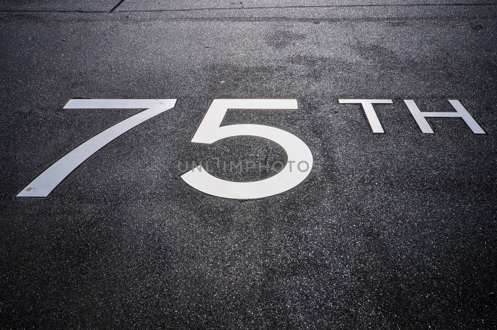 metal lettering 75th on the pavement on the promenade in front of hotel New York in Rotterdam Holland