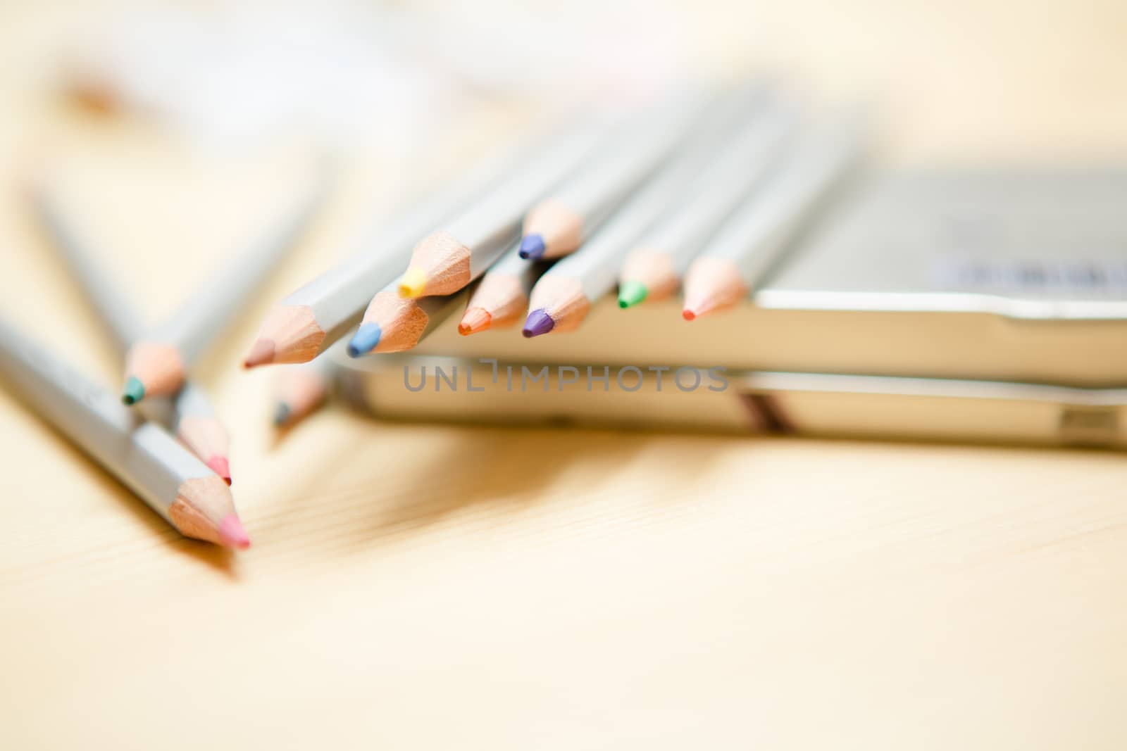 Close up of color pencils over wooden background by sarymsakov