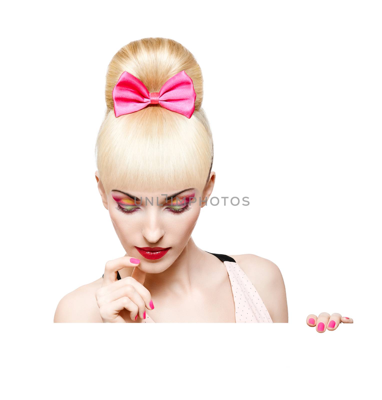 Portrait of beautiful woman peeking over edge of billboard, banner sign, people, isolated. Confident blonde girl with Pinup hairstyle, fringe and pink bow, make up. Face closeup. Billboard. 