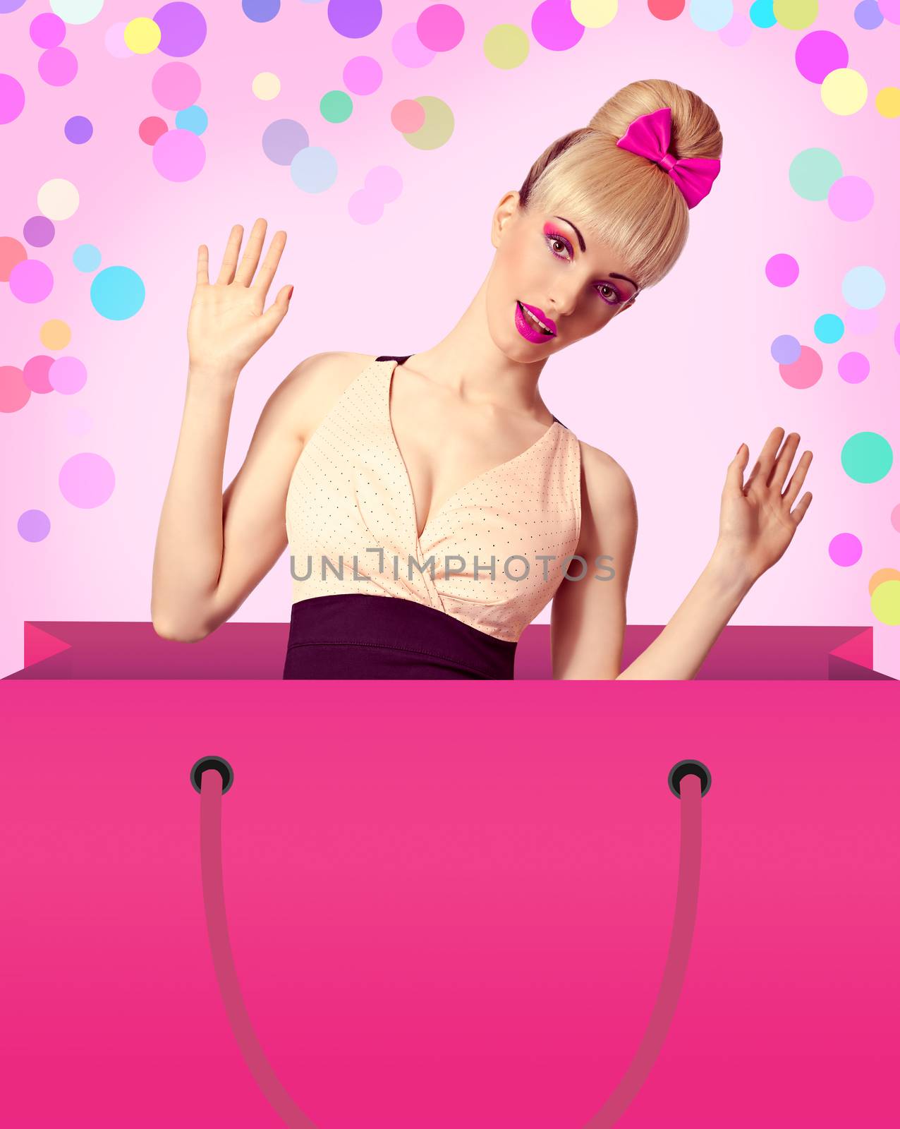 Beautiful woman in huge shopping bag surprised looks out of it on colored background with copy space. Pinup funny blonde girl, hairstyle with fringe and pink bow. Fashionable shopaholic. Vintage style