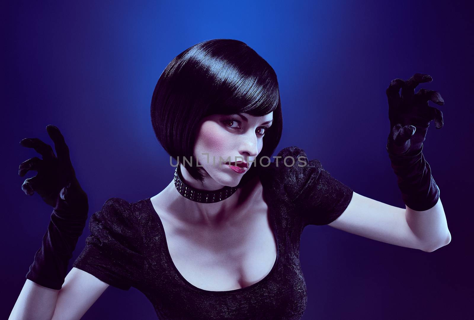Fashion beauty sexy brunette woman with silky bob hairstyle in black dress, tights, gloves. Sensual lady in stylish sunglasses and necklace. Unusual creative mysterious people. Blue dark background