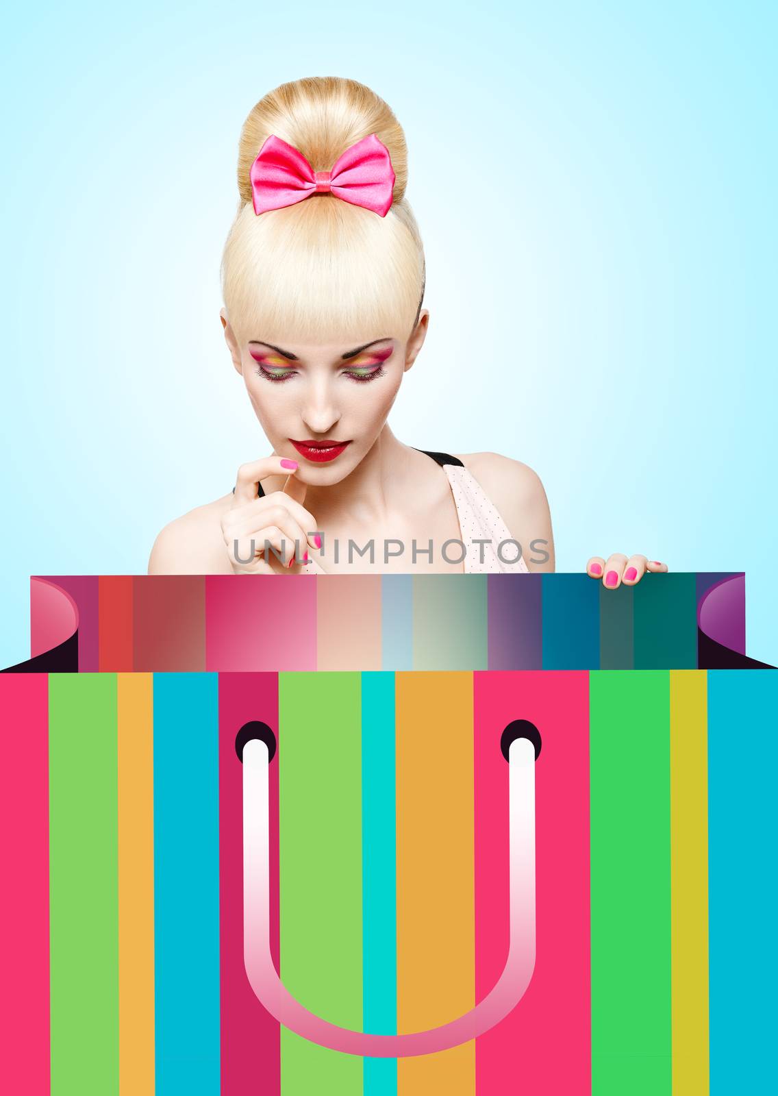Fashion beauty portrait of woman with huge shopping bag waiting for presents on blue background, people, copyspace. Confident blonde girl with Pinup hairstyle, fringe and pink bow. Billboard