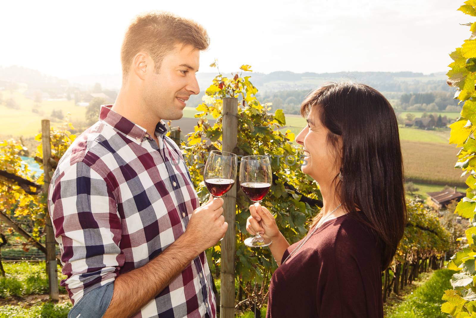 Couple tasting wine in a vineyard by sumners