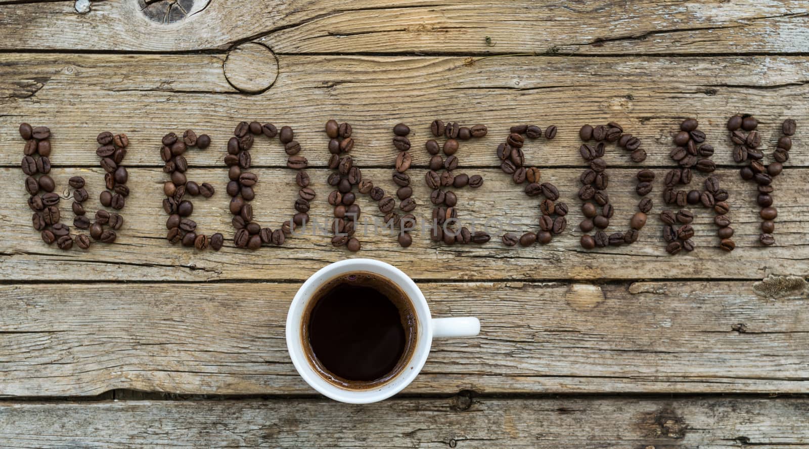 Cup of coffee on wooden background and WEDNESDAY coffee beans  by radzonimo