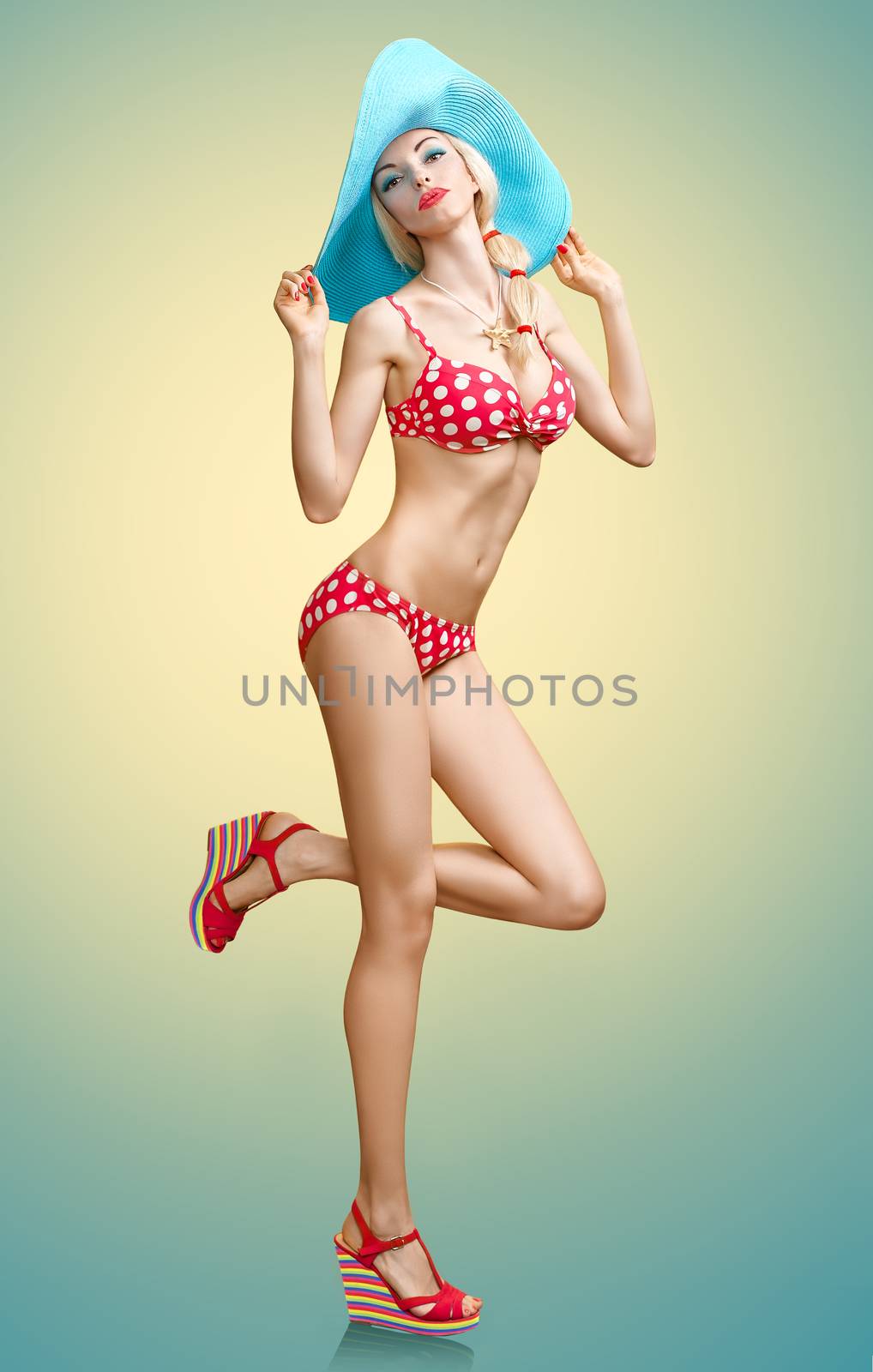 Beautiful woman in red polka dots fashionable swimsuit. PinUp playful sexy girl sensually looks, blue hat. Beach body, slim female figure, people, copyspace. Summer holiday, sea vacation 